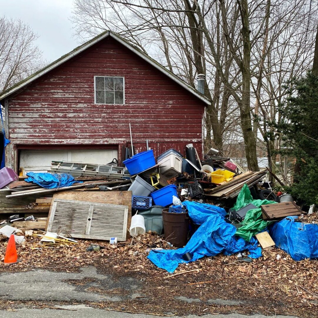 lance-grandahl-VSXT9AV19Is-unsplash A pile of trash sitting in front of a house.